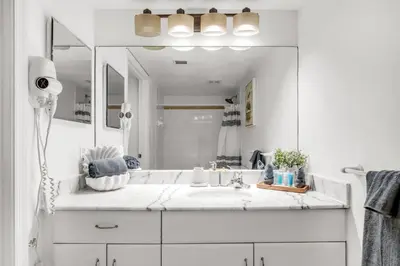 a white bathroom with a sink and a mirror at Perfectly Located Miami 3BR with Stunning Views in Miami
