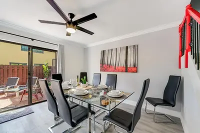 a dining room with a table and chairs and a ceiling fan at Spacious 4BR Miami Townhome with Communal Pool in Ives Estates