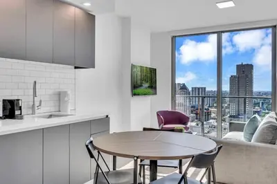 a kitchen with a table and chairs and a large window at Stylish Studio and Den Across from Bayside Miami in Miami