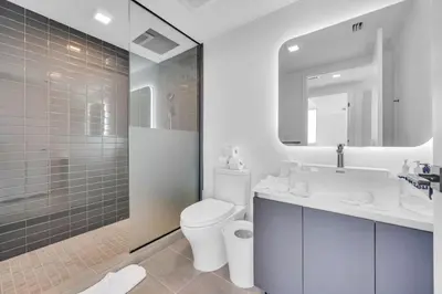 a bathroom with a toilet and a sink and a shower at Stylish Studio and Den Across from Bayside Miami in Miami