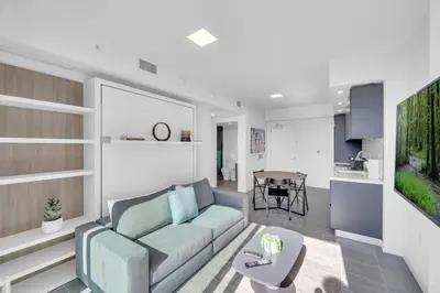 a living room with a couch and a table at Stylish Studio and Den Across from Bayside Miami in Miami