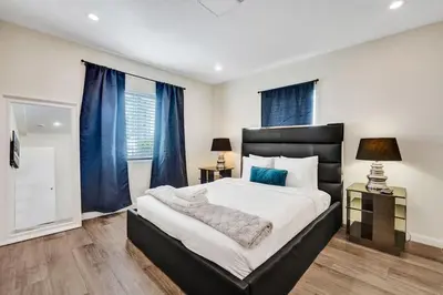 a bedroom with a large bed with blue curtains at Eden Escape 1 BR 2201 Walk to FLT Beach in Fort Lauderdale