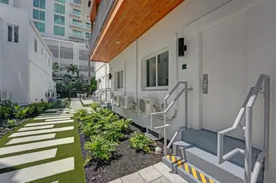 a corridor of a building with stairs and plants at Eden Escape 1 BR 2201 Walk to FLT Beach in Fort Lauderdale