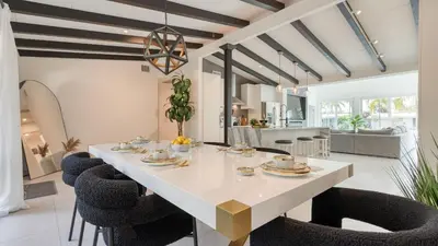 a dining room with a white table and chairs at Luxury Waterfront Home w Pool Hot Tub Dock Near Las Olas Gulfstream in Fort Lauderdale