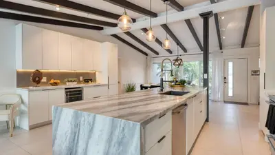 a large kitchen with a large marble counter top at Luxury Waterfront Home w Pool Hot Tub Dock Near Las Olas Gulfstream in Fort Lauderdale