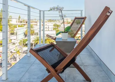 a wooden chair on a balcony with a table at 2Q Moderno em South Beach | Praia a 5 Min in Miami Beach