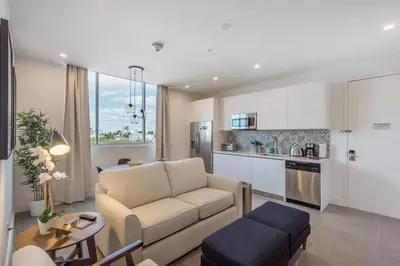 a living room with a couch and a kitchen at 2Q Moderno em South Beach | Praia a 5 Min in Miami Beach