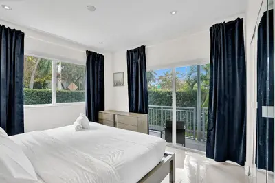 a bedroom with a large bed and a large window at Villa Monaco in Miami Beach