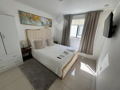 a bedroom with a bed with a television and a window at Modern Bedroom In Central Miami Shared with host in Miami