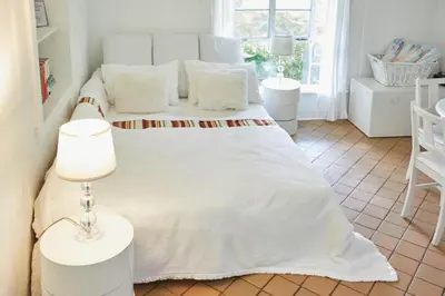 a bedroom with a large white bed with white pillows at Miami Pool Cottage in Miami