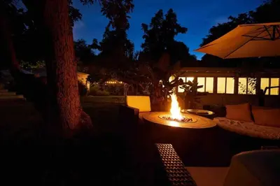 a fire pit with a table and an umbrella at Miami Pool Cottage in Miami
