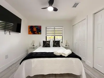 a bedroom with a large white bed with a ceiling fan at Little Havana Paradise in Miami