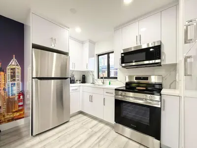 a kitchen with white cabinets and stainless steel appliances at Little Havana Paradise in Miami