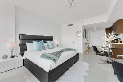 a bedroom with a large bed and a kitchen at Luxury Unit W Residences Brickell in Miami