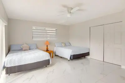 a bedroom with two beds and a ceiling fan at 8 Mi to Wynwood Waterfront Retreat with Lanai in Miami