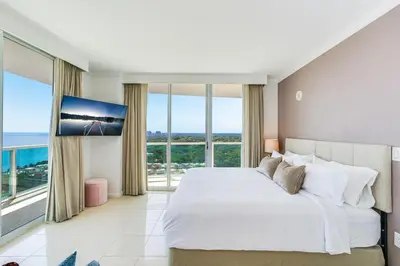a bedroom with a large white bed and large windows at 2 bedroom Bay View Beauty in Coconut Grove- Parking for 2 cars included! in Miami