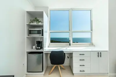 a white desk with a chair and a window at 2 bedroom Bay View Beauty in Coconut Grove- Parking for 2 cars included! in Miami