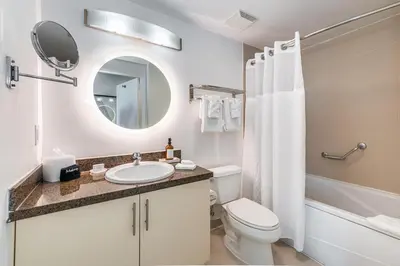 a bathroom with a sink and a toilet and a mirror at 2 bedroom Bay View Beauty in Coconut Grove- Parking for 2 cars included! in Miami