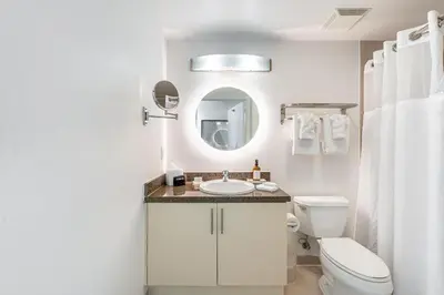 a bathroom with a sink and a toilet and a mirror at Coconut Grove Bayview unit Parking Included in Miami