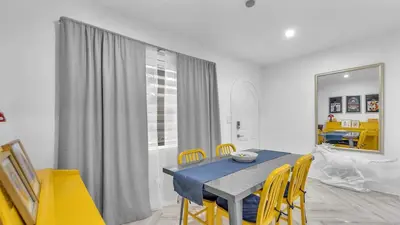 a dining room with a blue table and yellow chairs at Miami Designer Apartment Unit 2 in Miami