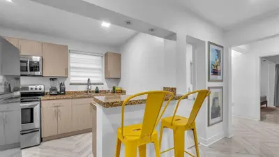 two yellow chairs sitting at a kitchen counter at Miami Designer Apartment Unit 2 in Miami