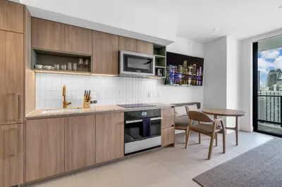 a kitchen with wooden cabinets and a table and a microwave at Hotel 601 in Miami