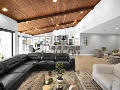 a living room with a black leather couch and a kitchen at Tropical Dream House in Plantation 3 Bedroom Home with Pool in Plantation