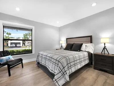 a bedroom with a bed and a window and a chair at Tropical Dream House in Plantation 3 Bedroom Home with Pool in Plantation