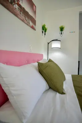 a bedroom with a white bed with a green pillow at Spacious Studio heart Of Miami in Miami