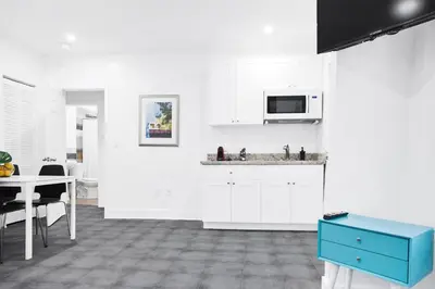 a kitchen with white cabinets and a blue drawer at Miami Designer Apartment Unit 4 in Miami