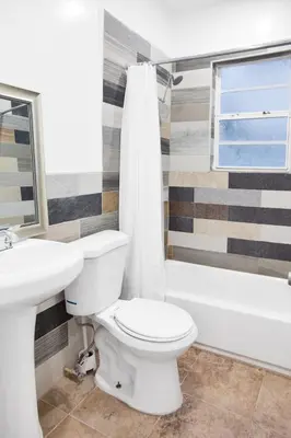 a bathroom with a toilet and a sink and a tub at Miami Designer Apartment Unit 4 in Miami