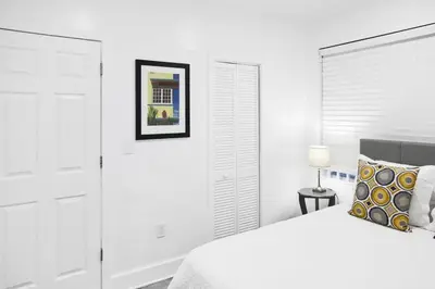 a white bedroom with a bed and a picture on the wall at Miami Designer Apartment Unit 4 in Miami