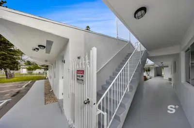 a white building with stairs on the side at Cozy 1-BD Miami Apt Gym, BBQ, Free Parking in Miami