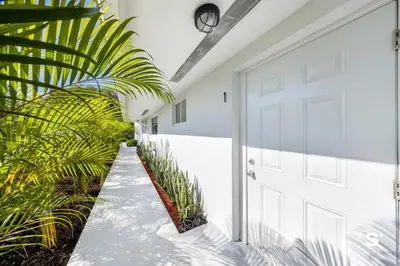 a white door in a hallway with plants at Cozy 1-BD Miami Apt Gym, BBQ, Free Parking in Miami