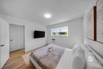 a white bedroom with a bed and a tv at Chic 1-BD Apt in Miami Gym, BBQ, Free Parking in Miami