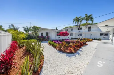 a house with flowers and plants in a driveway at Miami Retreat - 1-BR Parking, Gym & BBQ Area in Miami
