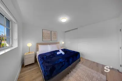 a bedroom with a bed with a blue comforter and a window at Modern 1-BD Miami Apt Gym, BBQ, Free Parking in Miami
