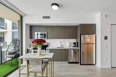 a kitchen with a table with a vase of flowers on it at Miami Penthouse Infinity Pool in Miami