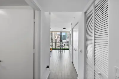 a hallway with white walls and a floor to ceiling window at Miami Penthouse Infinity Pool in Miami