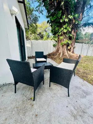 a group of chairs and a table and a tree at Modern Home with large private yard - Next to downtown & beach & airport - Pet friendly in Fort Lauderdale
