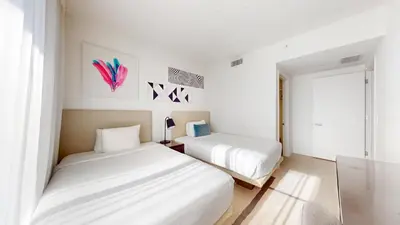 two beds in a room with white walls at Hyde Beach House 3BR2BA in Hollywood