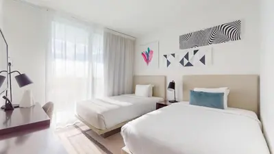 a white bedroom with two beds and a window at Hyde Beach House 3BR2BA in Hollywood