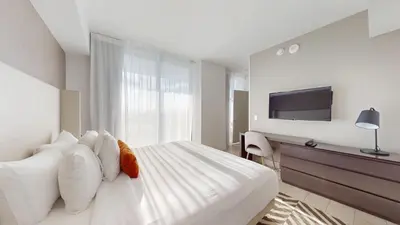 a bedroom with a large white bed with a flat screen tv at Hyde Beach House 3BR2BA in Hollywood