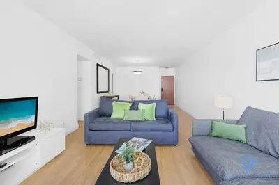 a living room with a blue couch and a tv at Tides beautiful ocean view condo-promotions in Hollywood