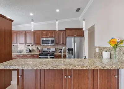 a kitchen with wooden cabinets and a granite counter top at Miami Oasis With Private Pool in Richmond West