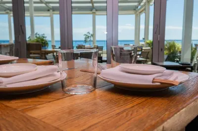 a wooden table with plates and glasses on it at Beach Apt Full kitchen and King size bed in Hallandale Beach