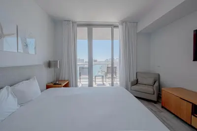 a bedroom with a bed and a chair and a window at Miami Beach 1B1B Apmt Amazing Intercoastal View in Hallandale Beach