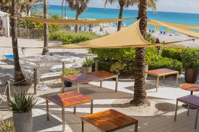 a group of tables and chairs next to the beach at Miami Beach 1B1B Apmt Amazing Intercoastal View in Hallandale Beach
