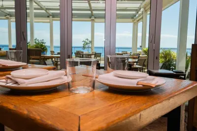 a wooden table with plates and glasses on it at Miami Beach 1B 1B Incredible View Apt with Kitchen in Hallandale Beach
