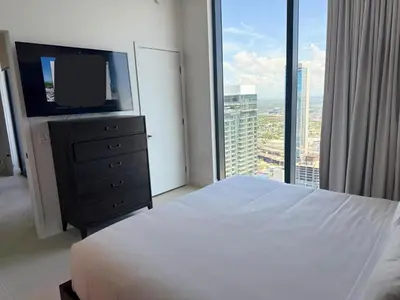 a bedroom with a white bed and a large window at Sky-High Views Pool – Steps from Miami Arena in Miami